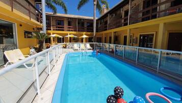 Relax by the pool surrounded by comfortable lounge chairs and umbrellas, with a clear view of the surrounding area.