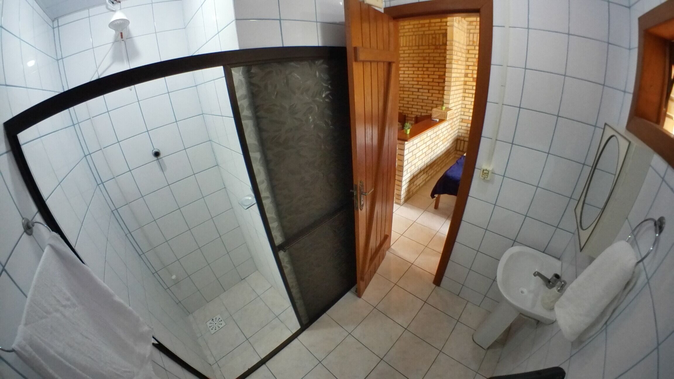 A bathroom with a shower, a sink, and a mirror.