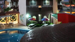 Un hôtel à plusieurs étages doté de balcons, d’une piscine et d’une enseigne indiquant « HÔTEL LEO ».