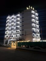 Un hotel de varios pisos con balcones y un llamativo letrero 'HLEO' en la parte superior.