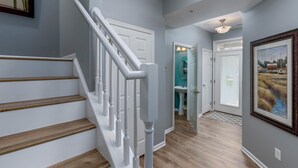 A staircase with white railings and wooden steps leading to a landing. - Amazing 4 Bedroom Sunset Island Townhome with Bonus Den! (Ocean City)