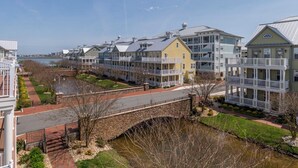A waterfront residential area with multi-story buildings, a stone bridge, and a river. - Amazing 4 Bedroom Sunset Island Townhome with Bonus Den! (Ocean City)