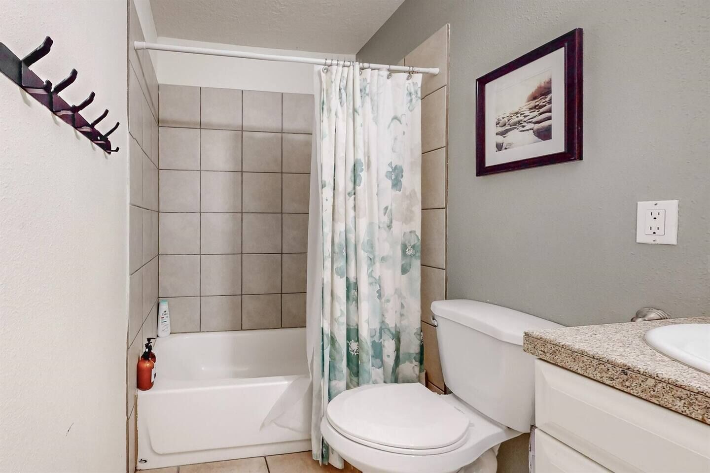 Een badkamer met een douche, toilet en wastafel.