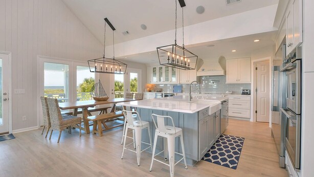 A modern kitchen with a central island, white cabinetry, and stainless steel appliances. - "Love At First Sight" - Oceanfront Home w/ Private Pool, 7 Bedrooms / 5.5 Bathrooms (Holden Beach)