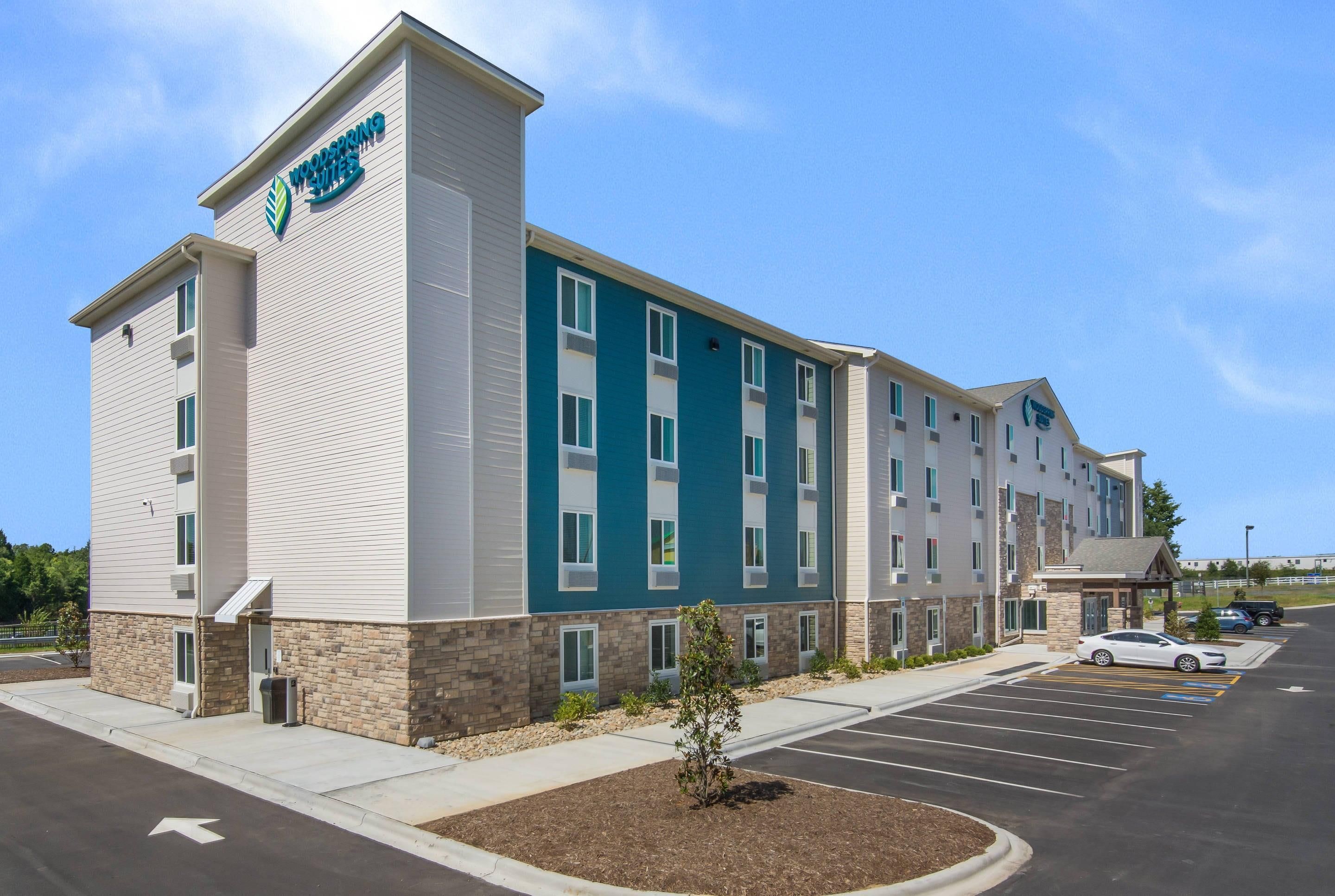 A multi-story hotel with a flat facade, large windows, and a parking lot.
