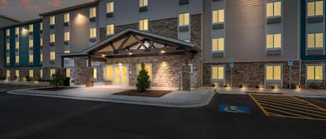 A hotel with a stone facade, multiple windows, and a covered entrance.