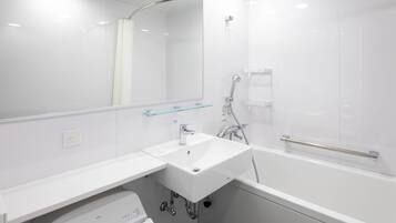 A modern bathroom with a white sink, mirror, and bathtub.
