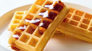 Two waffles with syrup being poured over them. - Comfort Hotel Matsuyama (Matsuyama)