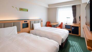 A hotel room with two beds, a desk, a chair, a TV, and a window with curtains.