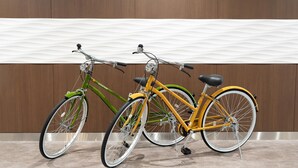 Two bicycles parked against a wooden wall with a tiled floor. - Comfort Hotel Matsuyama (Matsuyama)