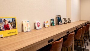 Un long comptoir d’accueil en bois, agrémenté de plusieurs affiches d’information et d’un écran numérique.
