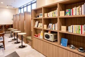 Eine Bibliothek mit Holzbögen, einer Mikrowelle und Tischen mit Stühlen.