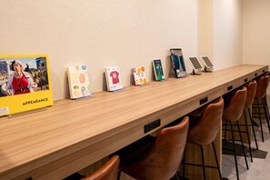 Ein langer Holzerrezeptionstresen mit mehreren Informationspostern und einer digitalen Anzeige.