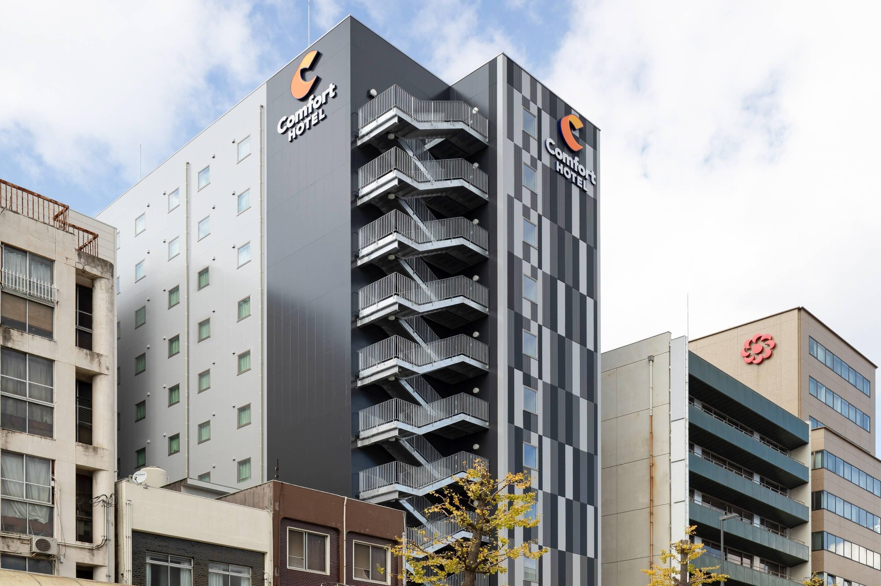 Edificio de Comfort Hotel con un diseño moderno, que cuenta con varios balcones y un logotipo destacado.