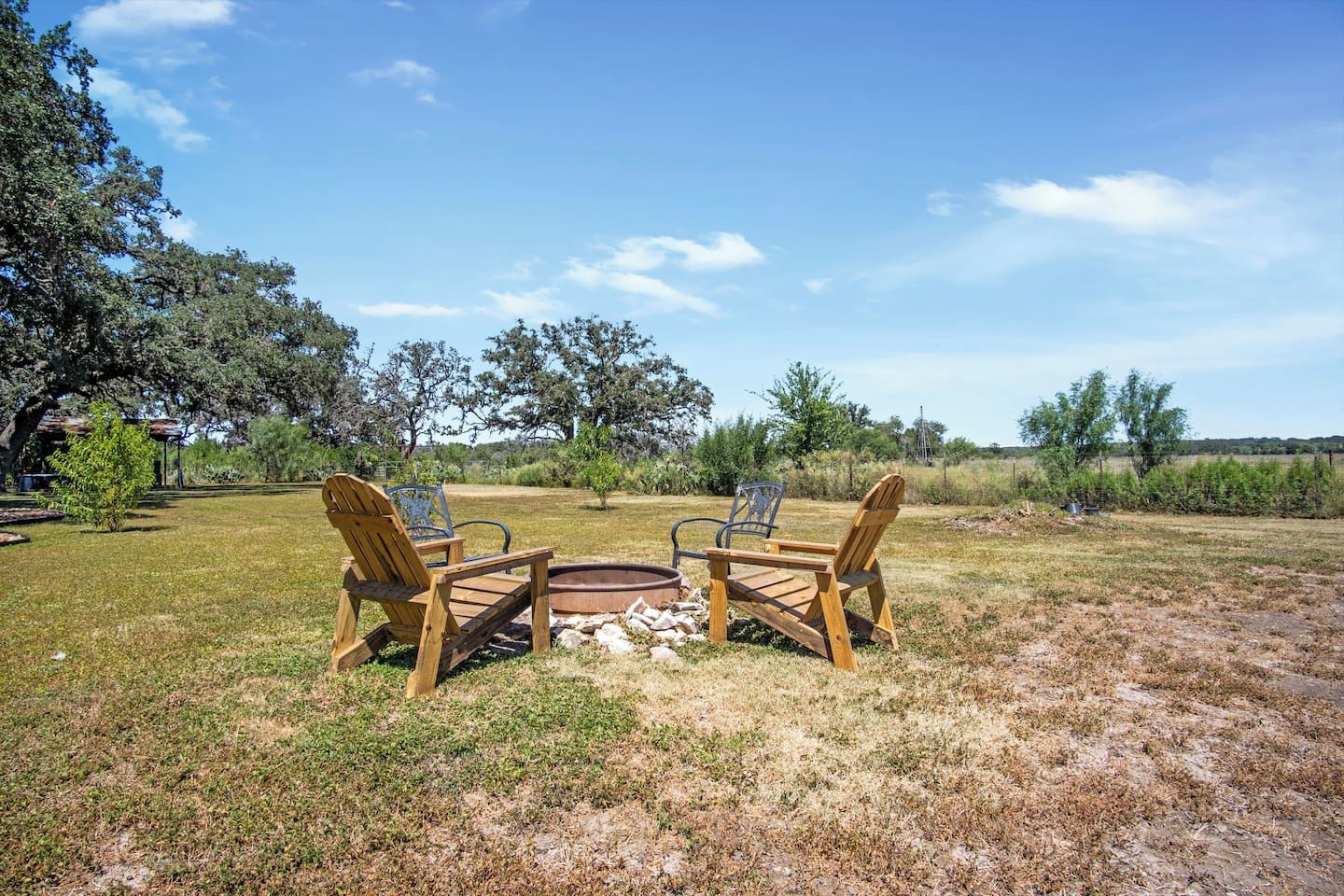 An outdoor seating area with two wooden chairs and a small fire pit.