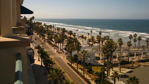 Una calle costera con palmeras, una playa y olas del océano.