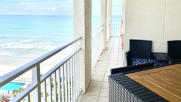 Un balcon avec vue sur l’océan et une piscine.
