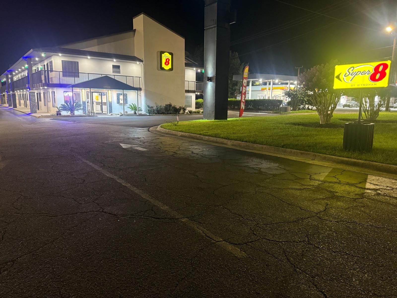 A Super 8 hotel with a large sign, a parking lot, and a well-lit entrance.