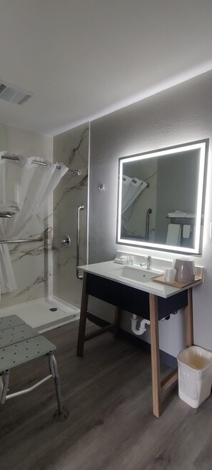 Une salle de bain avec une douche en marbre, un meuble-lavabo avec un miroir et des toilettes.
