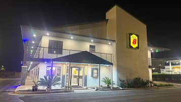 A Super 8 hotel with a two-story structure, an office on the ground floor, and a balcony on the upper level.