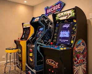 Arcade machines with 'Star Wars' and 'Pac-Man' themes, a neon sign reading 'ARCADE,' and a stool in front of the machines. - Luxury Chalet Masthope Near Narrowsburg & Delaware (Masthope)