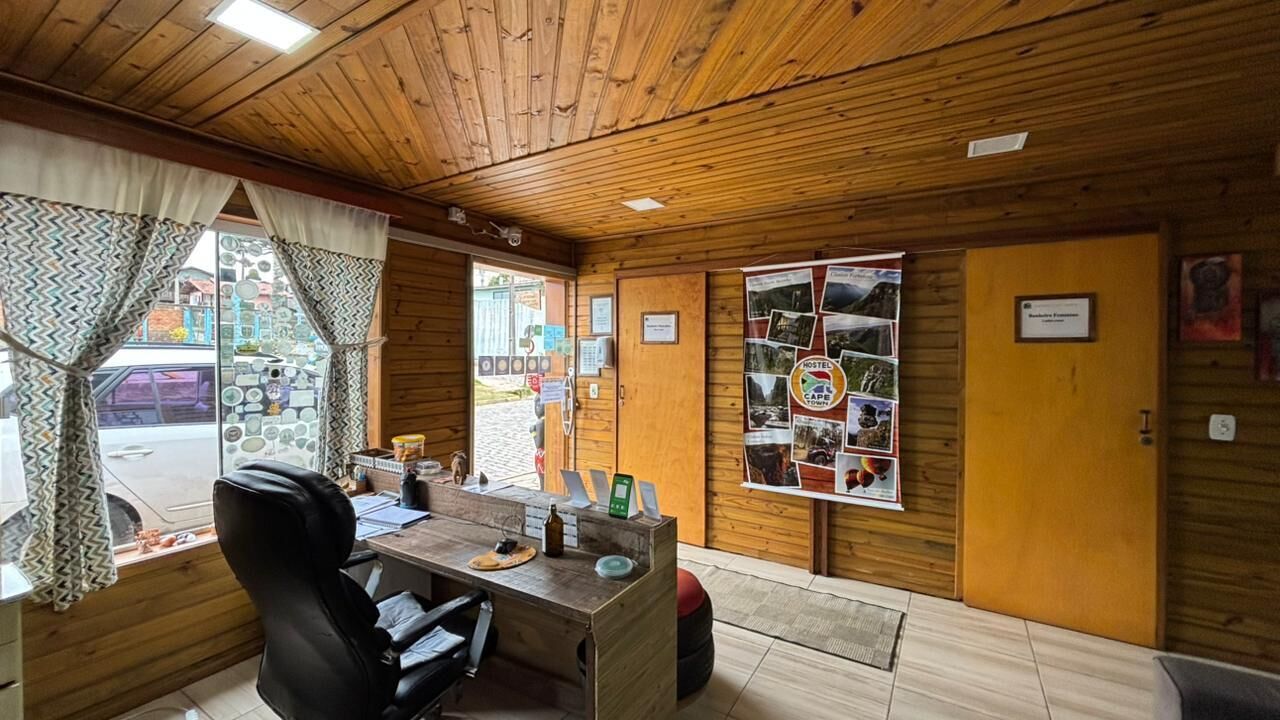 Un interior de madera con un escritorio, una silla y un tablón de anuncios con fotografías.
