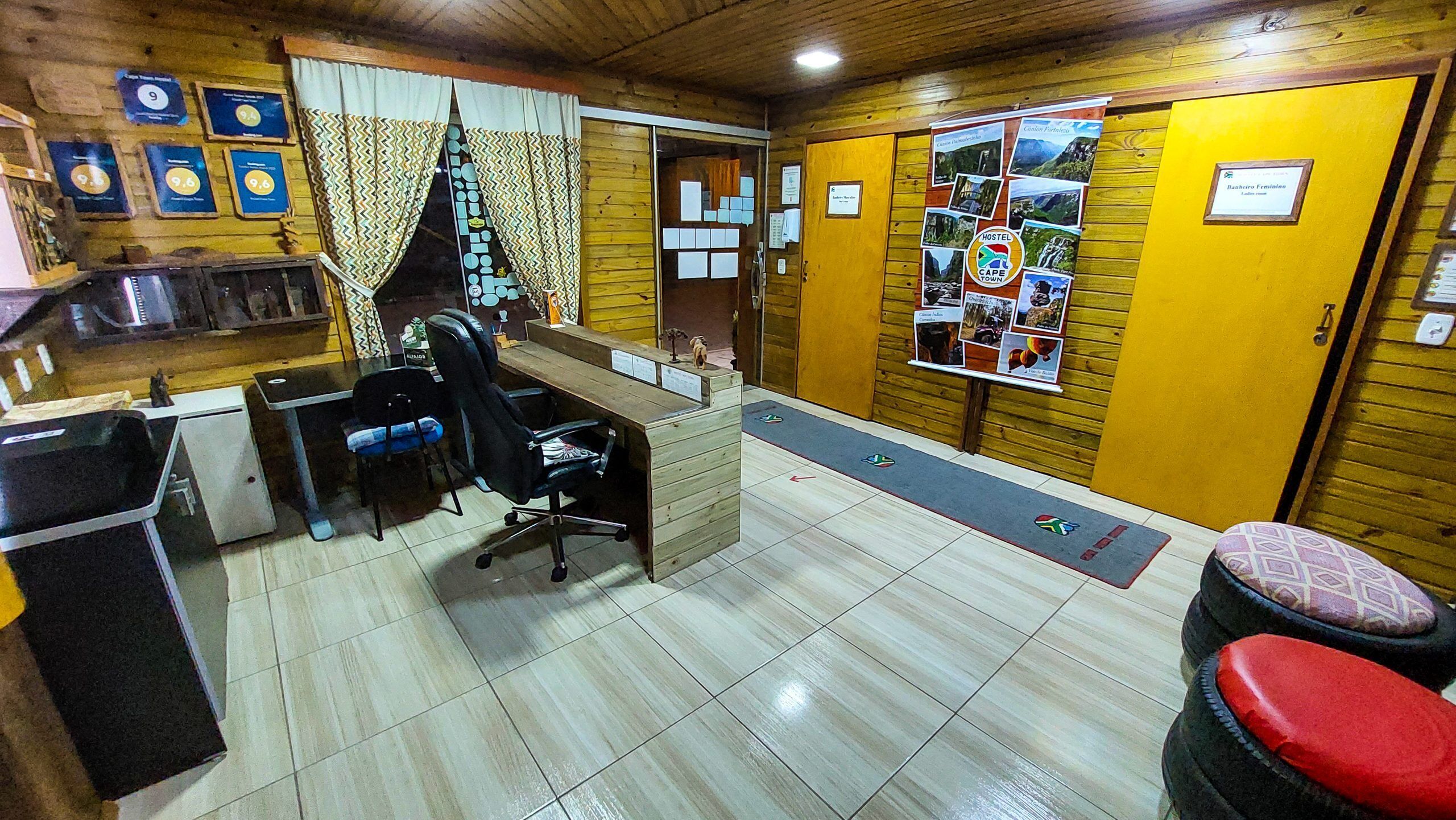 A reception area with a desk, chairs, a trash bin, and informational posters on the walls.