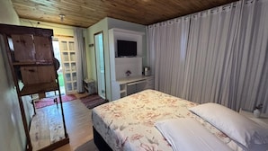 Un dormitorio con cama, escritorio, televisor y armario.