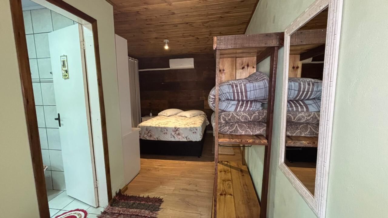 Un pasillo estrecho con una cama, un armario y una puerta que da a otra habitación.