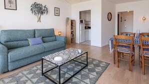 Een moderne woonkamer met een bank, salontafel en eethoek.