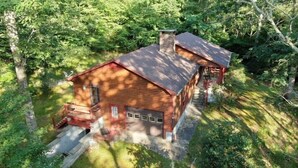 A rustic cabin with a chimney, surrounded by dense forest. - Pet-Friendly 3 Bedroom Home with Fireplace (Banner Elk)