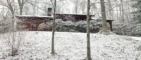 En stuga i en snötäckt skog.