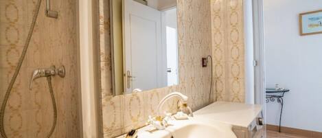 Une salle de bain avec une douche, un lavabo et un miroir.