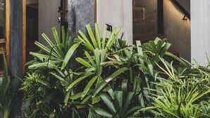 A concrete staircase with a metal railing, surrounded by lush green plants. - The Saren (Tabanan)