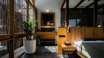 Un dormitorio moderno con un ventanal grande, una cama de madera, una mesita de noche y una planta en maceta.