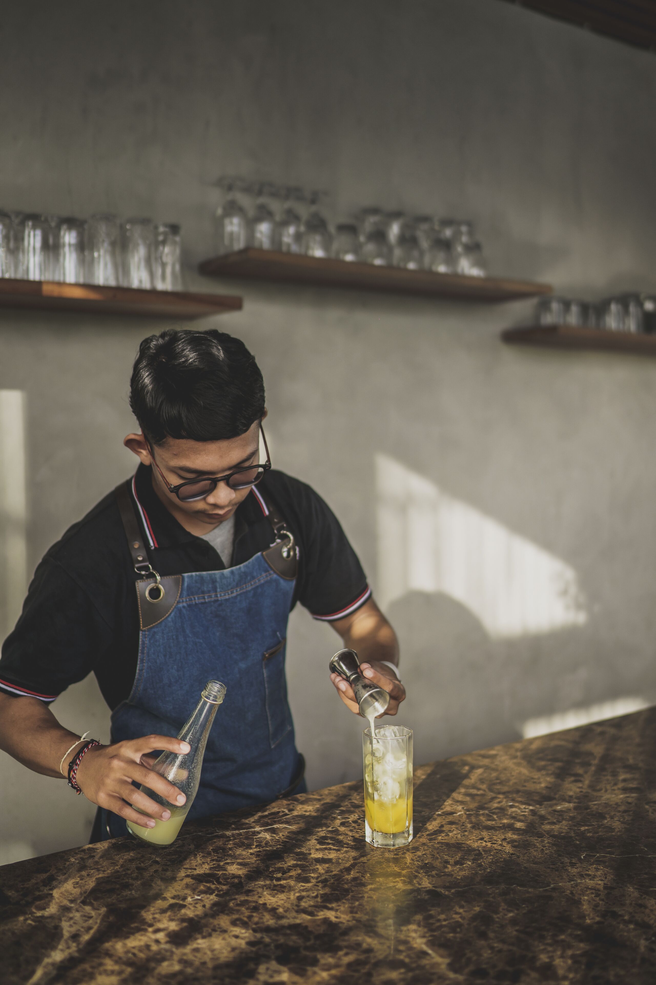 A person pouring a drink into a glass.