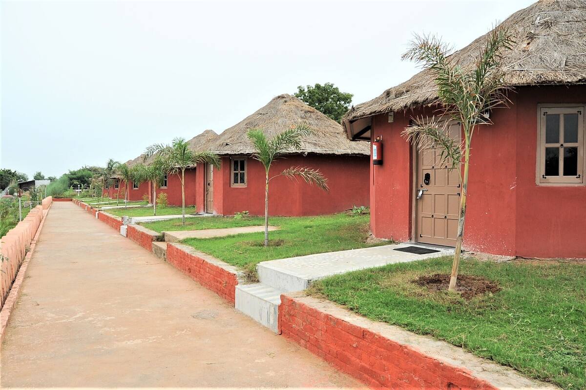 A row of red-roofed cottages with a paved walkway in between.