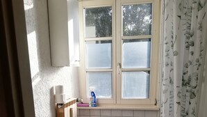 Un baño con inodoro, lavabo, ventana y lavadora.