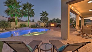 A pool area with lounge chairs and a covered patio. - Modern Azure Home w/ Beautiful Patio, Pool & Spa! (Goodyear)