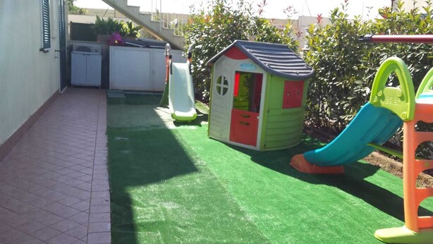A small play area with a slide and a playhouse.