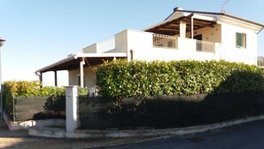A two-story house with a covered porch and a small balcony.