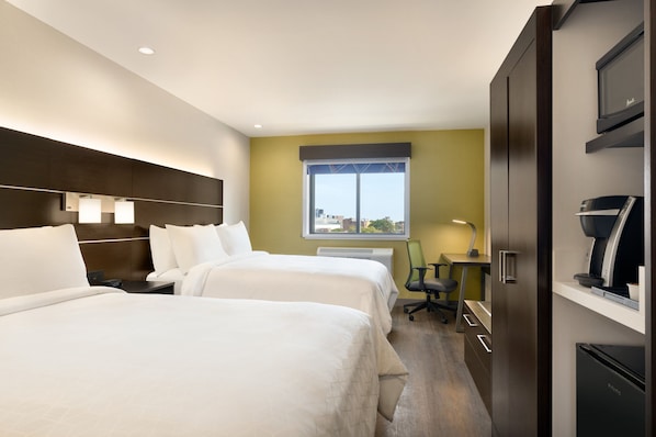 Une chambre d’hôtel avec deux lits, un bureau, une chaise, une télévision et un mini-bar.