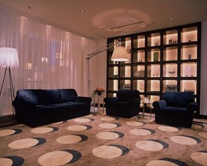 Relax in style with a sofa, armchairs, and a floor lamp in this elegant living area.