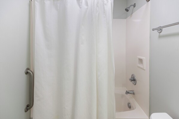 Un baño con ducha, inodoro y lavamanos.