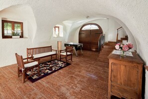 A cozy room with a wooden bench, a foosball table, a wooden cabinet, and a staircase leading to another level.