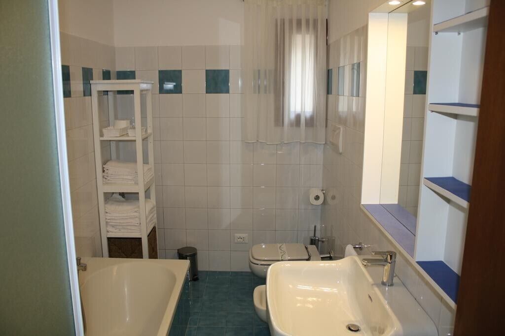 Un baño con bañera, inodoro, lavabo y un perchero para toallas.