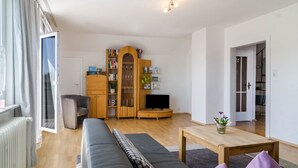 Una sala de estar moderna con un sofá, un mueble de madera, un televisor y una mesita.