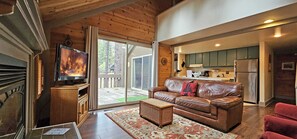 A cozy living room with a leather couch, a television, and a large window. - 4 Pole House-Sunriver, Oregon: BBQ, WiFi, SHARC Aquatics, Tubing Hill, Mt. Bachelor, Golf, Deschutes River, Tennis, Bike Paths (Sunriver)