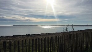 A coastal view with a wooden fence in the foreground and a calm sea. - T2 Les Lilas ,plage 300m (Hyères)