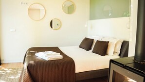 A hotel room with a bed, pillows, a mirror, and a TV.